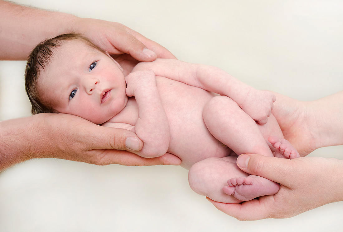 Newborn baby Porter in Mom and Dad's hands